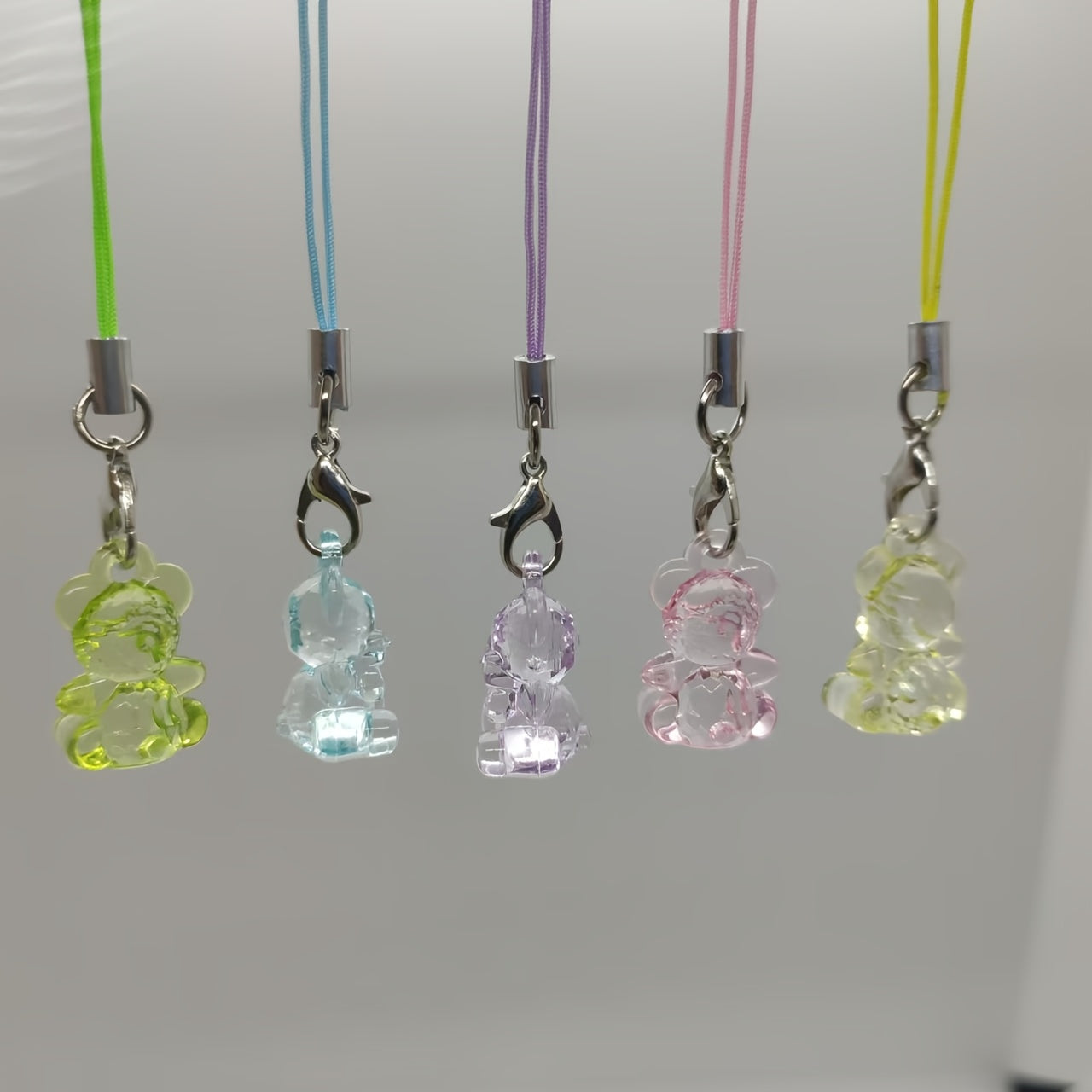A Collection of 5 Adorable Clear Bear Mobile Phones, Keychains, And Backpack Charms.